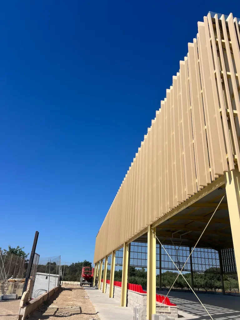Acabado moderno y cálido con protección solar de madera tecnológica integrada en la instalación deportiva
