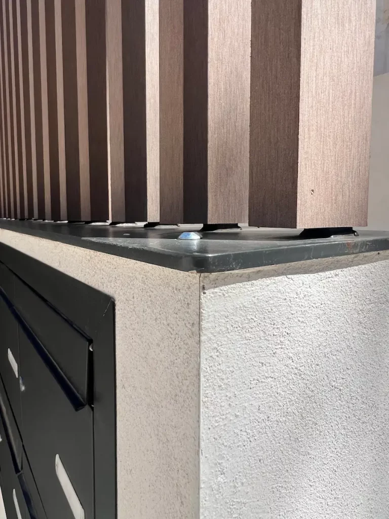 Acabado exterior de paredes de fachada con lamas de madera tecnológica en zonas comunes